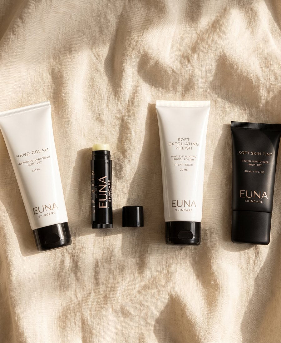 EUNA hand cream, lip balm, exfoliating polish and skin tint on linen